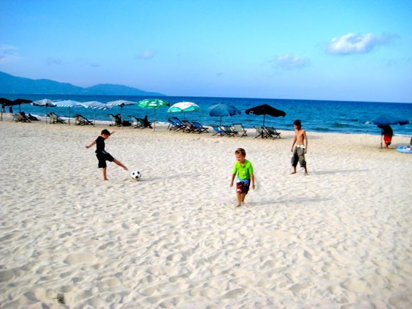 The kids playing soccer on a beach near Danang
