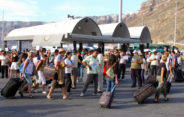 Hotel owners meeting arriving ferry passengers on Santorini.