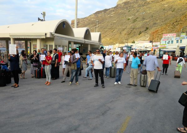 Hotel owners meeting an arriving ferry on Santorini.