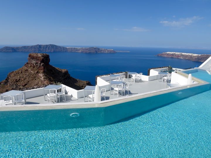 Pool and Restaurant with view of caldera and Therassia in Santorini.
