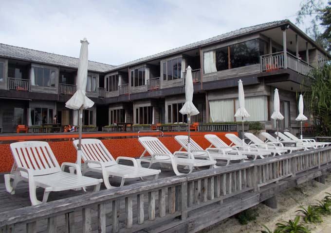 Wooden rooms and orange beachside pool at small Baan Ploy Sea