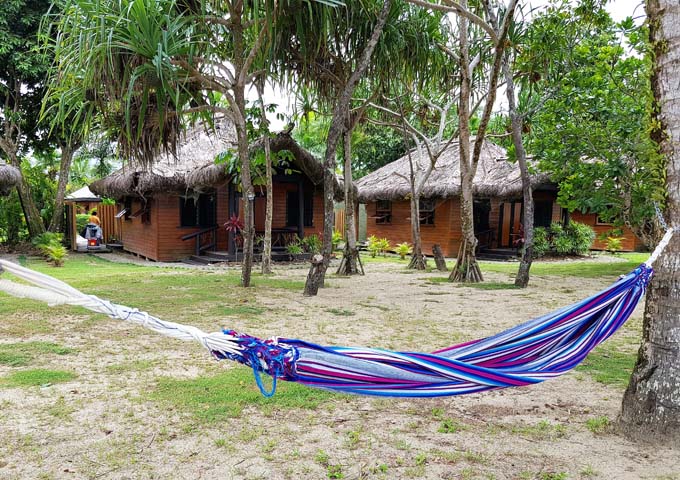 The resort has a tropical vibe with palms, sand and hammocks.