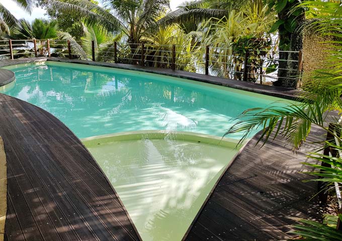 The pool at Paradise Cover Resort is surrounded by tropical foliage.