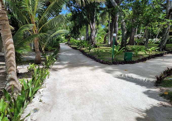 The resort features sandy paths and lush gardens.