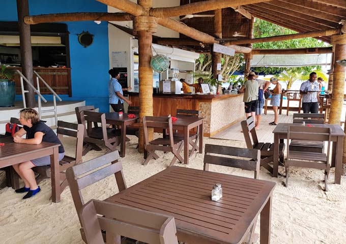 The restaurant features tables on the sand.