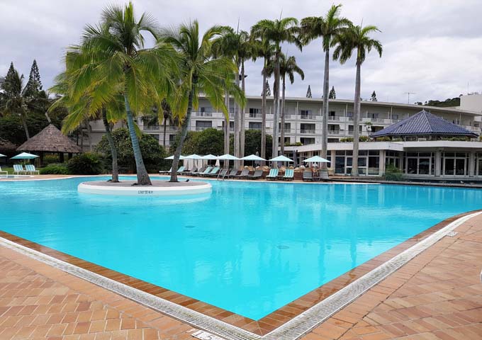 Large pool with palm island at kids-friendly Le Méridien Noumea Resort & Spa.