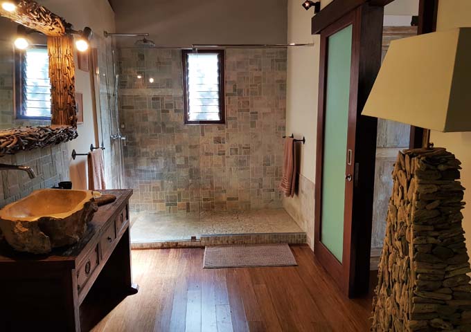 The spacious bathrooms feature stone-wall showers and wooden sinks.
