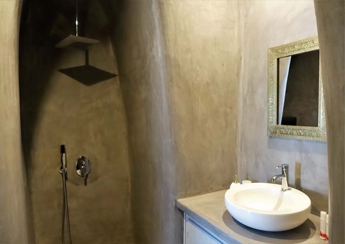 The villa bathroom features a unique cave-style shower.