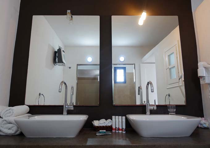 The bathroom has dual basins and mirrors.