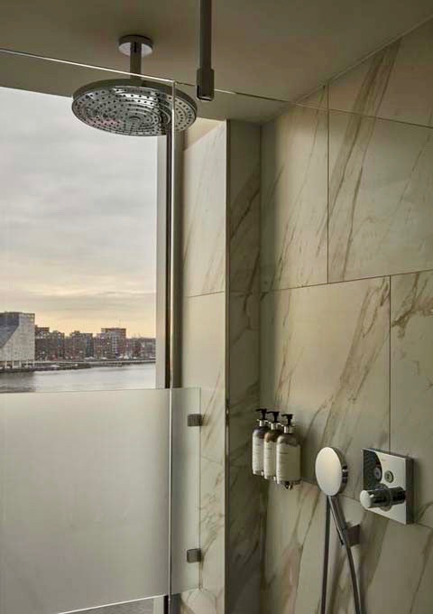 The Deluxe Corner Rooms rain shower offers great views of the city.