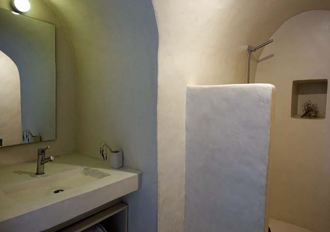 The bathroom is traditional with pressed concrete and open shower.