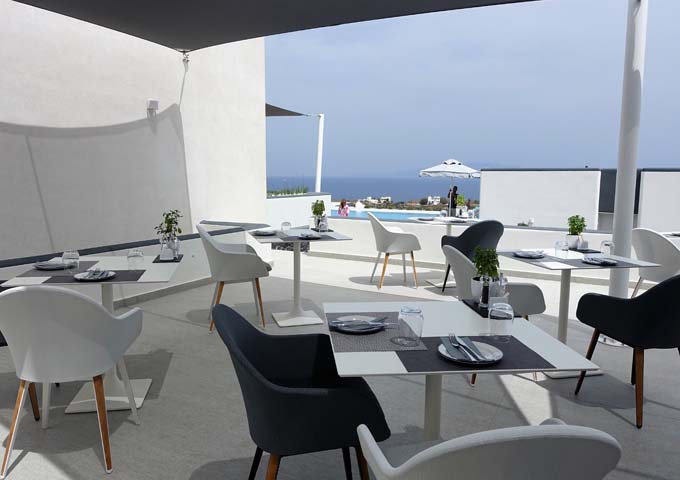 The restaurant's outdoor seating overlooks the pool and the sea.