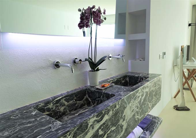 The bathroom has dual marble sinks.