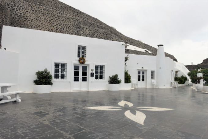 The exterior of the hotel feature Cycladic architecture with lava rock.