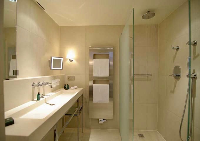 All rooms feature rain showers; higher categories include a tub also.