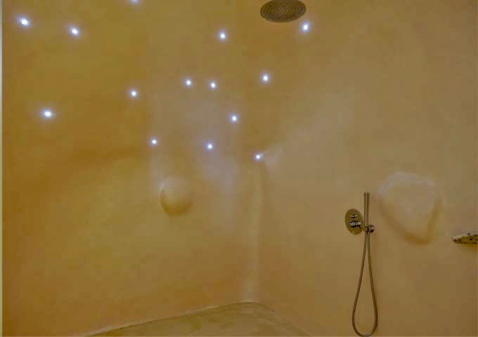 The cave-style shower features small, pinpoint lights.