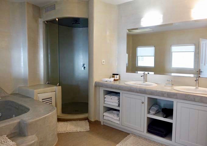 The spacious bathroom has a jacuzzi tub, Greek shower, and dual vanities.