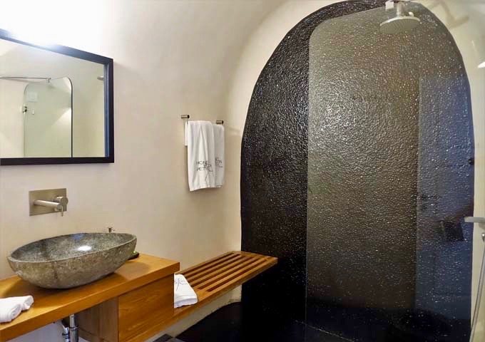 The main bathroom has a stone sink and rain shower.