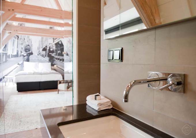 Wolvenstraat suite features an open-plan bathroom with rain shower and tub.