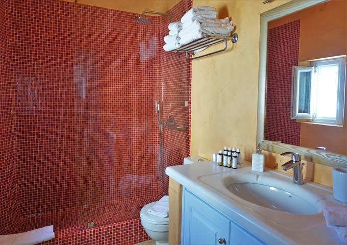 The colorful bathroom has a glassed-in rain shower.