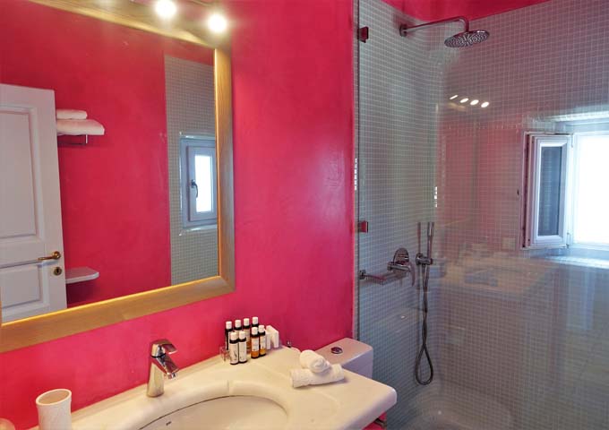 The suite has a colorful bathroom and tiled rain shower.