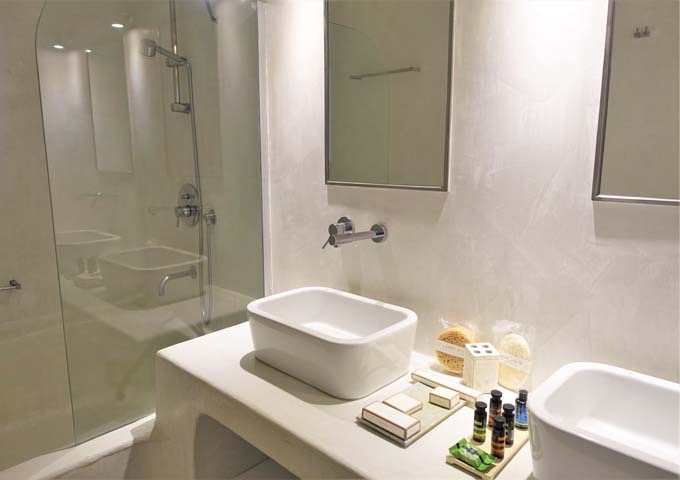 The bathroom has dual vanities and Apivita amenities.