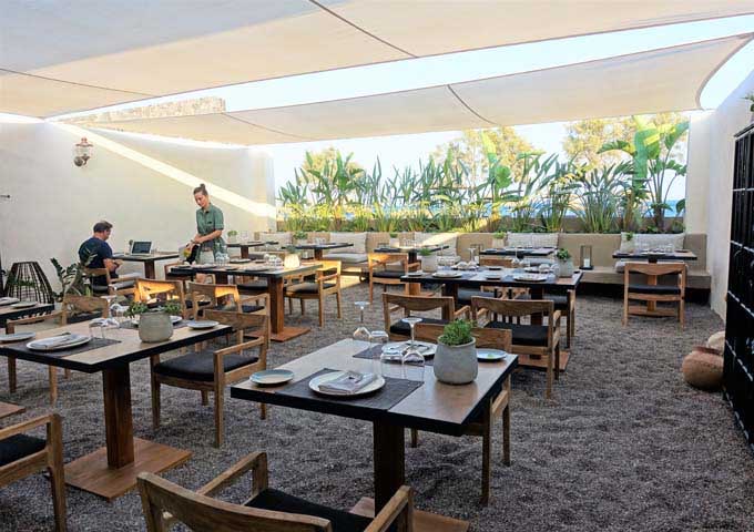 Mr. E restaurant features black sand floor and tented roof.