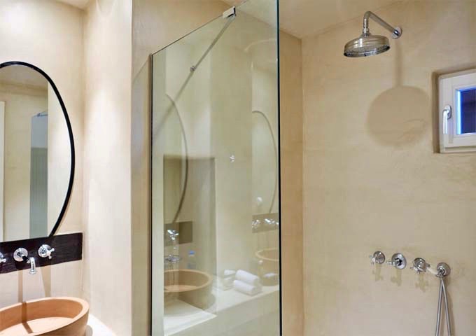 The suite's bathroom has a shower with a glass partition.
