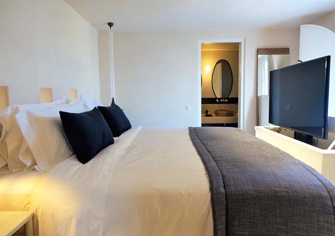 The bedroom has a king bed with a large, hideaway TV, and access to the rooftop terrace and jacuzzi.