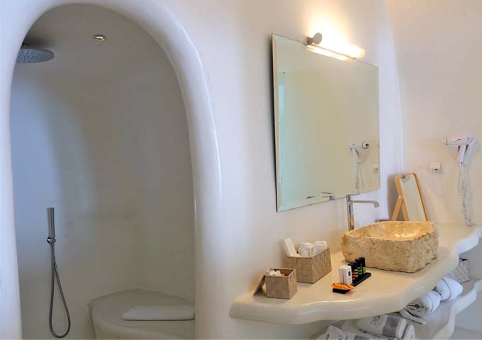 The bathroom has a unique cave-style open shower.