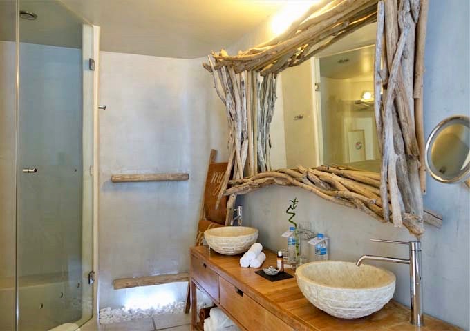 The spacious bathroom has dual vanities and a glass shower.