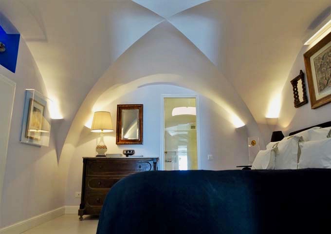 The bedroom has a vaulted ceiling and antique furnishings.