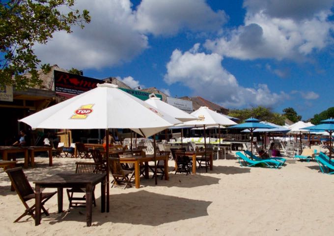 The Muaya Beach cafes set up tables on the sand for sunset dinners.