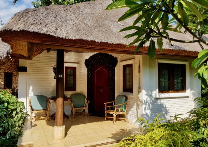 The traditional cottages feature thatched roofs and wooden doors.