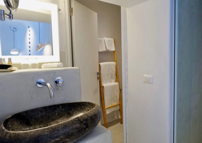 The traditional bathroom have stone sinks and pressed concrete vanities.