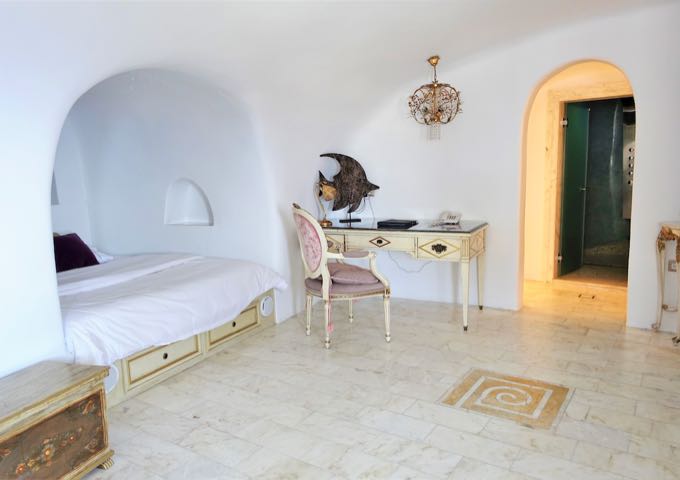 The Eros Cave Pool Suite has a spacious bedroom with antique furniture.