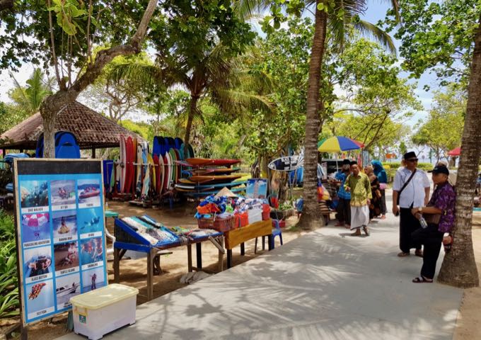 The beachside path is lined with water-sports counters and souvenir stalls.