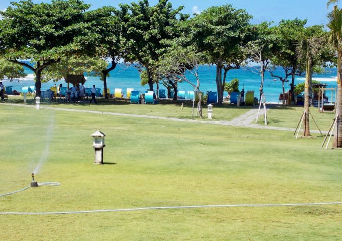 Extensive lawns spread out between the pool and the beach.