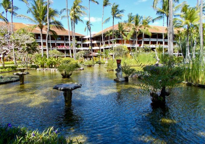 The vast resort grounds feature ponds, statues, palms, fountains.