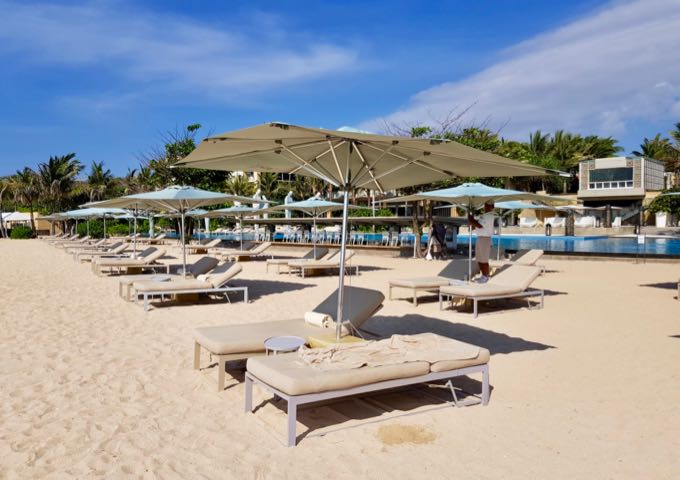 The resort beach has several lounge chairs with umbrellas.
