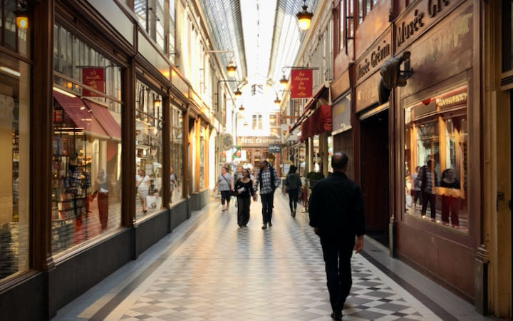People walking through a covered shopping arcade in Paris