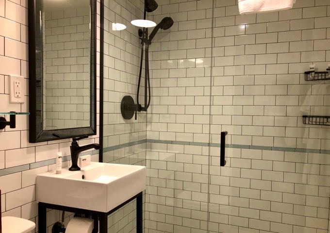 White tile bathroom in Hotel Theodore guest room