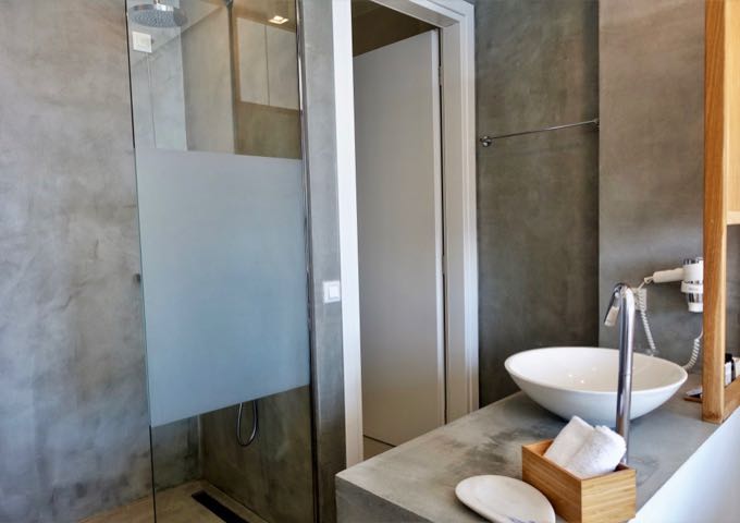 The bathrooms come with pressed concrete, glass walls, and bowl-style sinks.