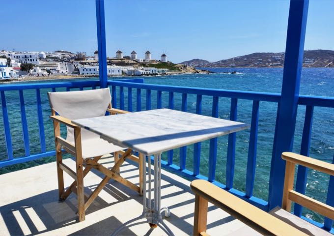 The colorful balcony has an al fresco dining table and excellent views of the Kato Mili windmills and the Chora.