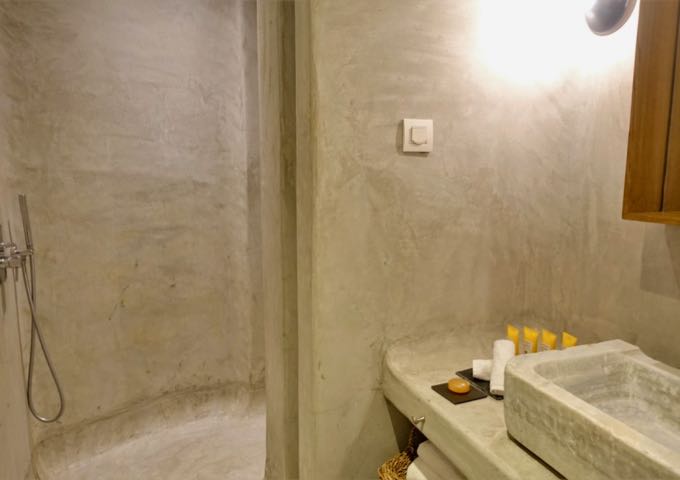 The Bohemian Suite's bathroom comes with a Greek-style open shower, pressed concrete, and antique marble sink.