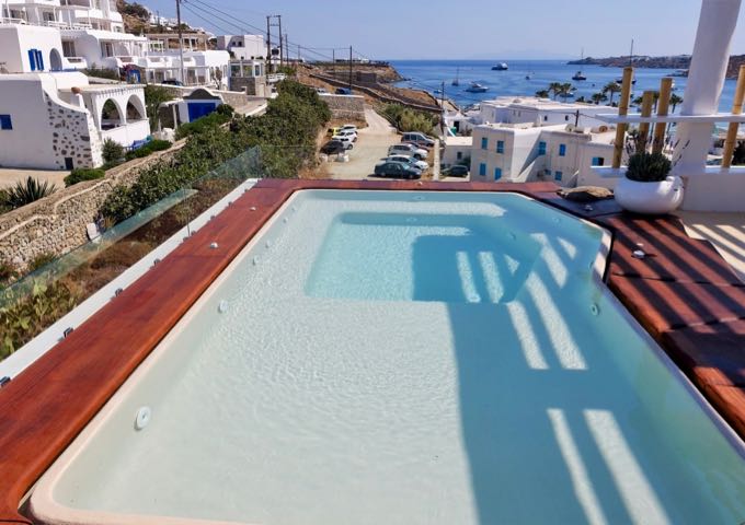 The rooftop hot tub offers panoramic views of Ornos Bay.
