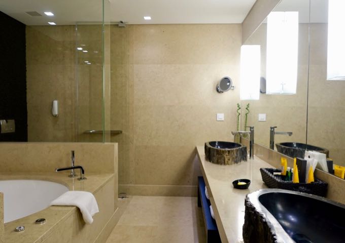 The large bathrooms have glass showers, bathtubs, and dual vanities.
