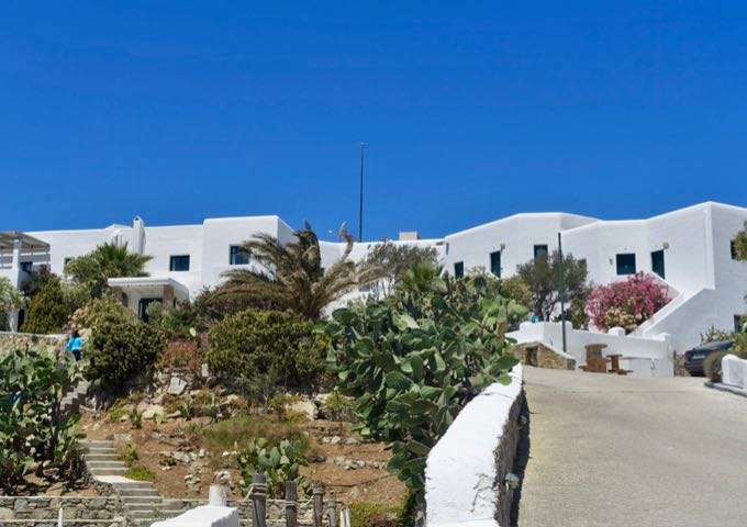 The hotel features a classic Cycladic architecture with stonework.