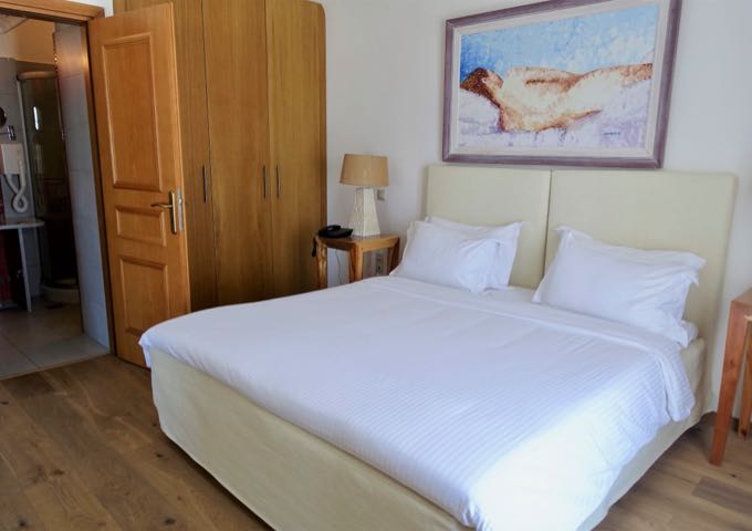 The suite's bedroom features luxury linens, ensuite bathroom, and access to the balcony.