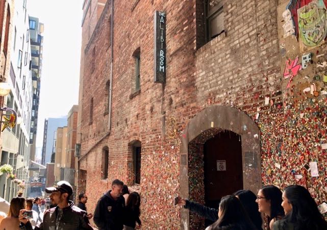 Tourists taking photos at Pike Place Market's Gum Wall.